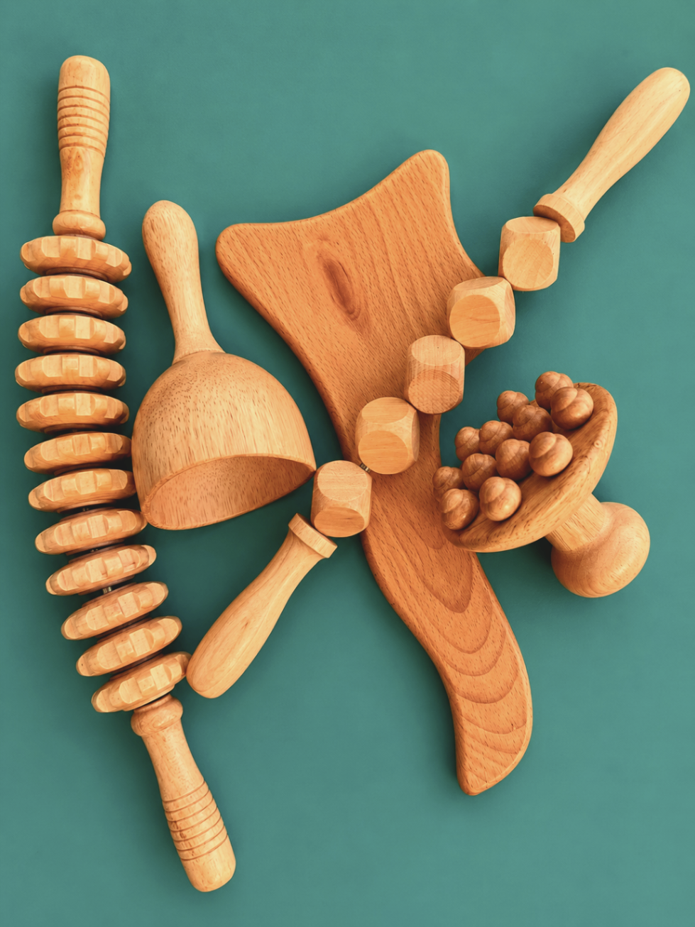 A set of wooden madero therapy tools arranged on a teal background